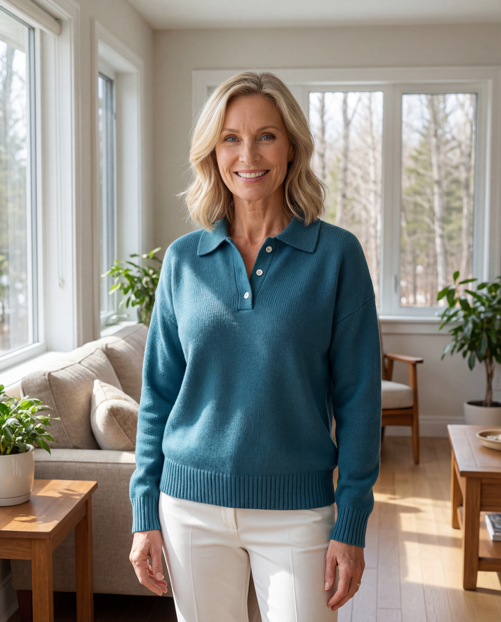 Womens collared knit pullover sweater with long sleeves, button placket and relaxed fit styled with casual trousers indoors