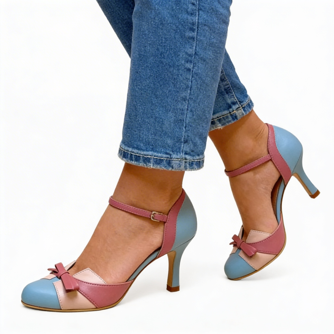 Womens retro bow detail colour block heels featuring a rounded toe, ankle strap fastening, contrast panel design and slender high heel