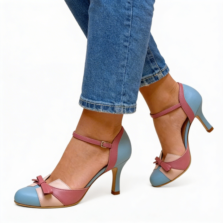 Womens retro bow detail colour block heels featuring a rounded toe, ankle strap fastening, contrast panel design and slender high heel